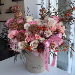 Pink and white rose bouquet in a beige hatbox with a pink ribbon