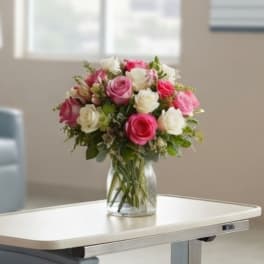 Pink and white rose bouquet in a clear glass vase