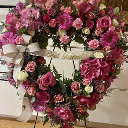 Heart-shaped floral wreath with pink roses and a ribbon reading Best Friend