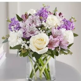 Bouquet of white and lavender flowers in a clear glass vase