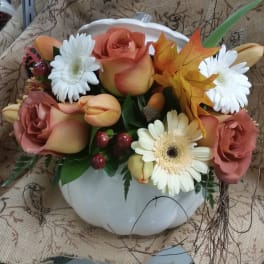 Mixed bouquet in a white pumpkin-shaped vase with roses and daisies