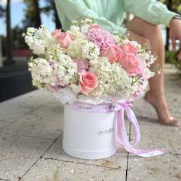 Pink and white flower arrangement in a white hat box with ribbon