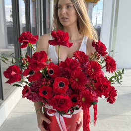 Woman holding a large red bouquet in a round box