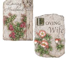 Two decorative memorial stones with floral relief and engraved names