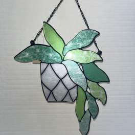 Hanging stained-glass plant with green leaves in a black metal frame