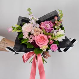 Hand-tied bouquet of pink and white flowers with a pink ribbon