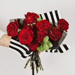 Bouquet of red roses wrapped in black-and-white striped paper
