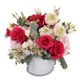 Pink and white rose arrangement in a white hatbox