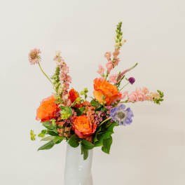 Colorful mixed flower arrangement in a white vase