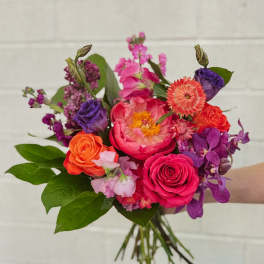 Handheld bouquet of pink, orange, and purple flowers