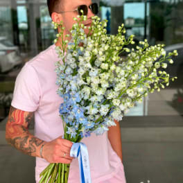 Man holding a large bouquet of blue and white flowers