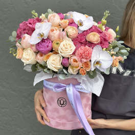 Pink and peach bouquet in a round pink box with white orchids