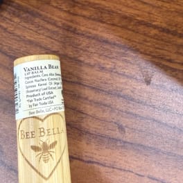 Vanilla Bean lip balm tube on a wooden surface