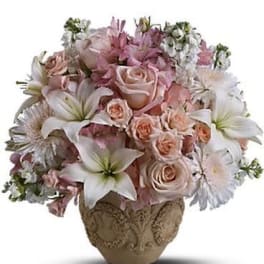 Pink and white floral arrangement in a decorative vase