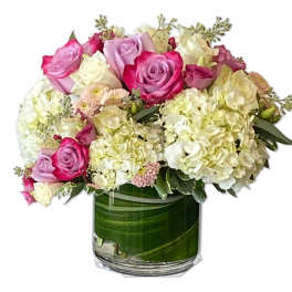 Pink and white roses with hydrangeas in a glass vase