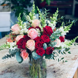 Bouquet of red and blush roses in a clear glass vase