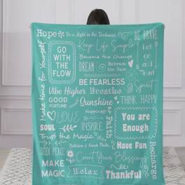 Person holding a teal blanket with white inspirational phrases