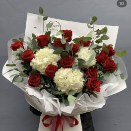 Bouquet of red roses and white hydrangeas wrapped in white paper