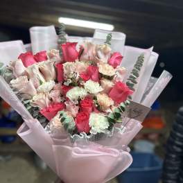 Pink and white rose bouquet wrapped in pale pink paper
