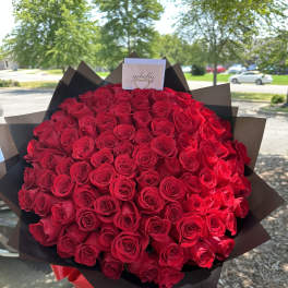 Large bouquet of red roses wrapped in dark paper