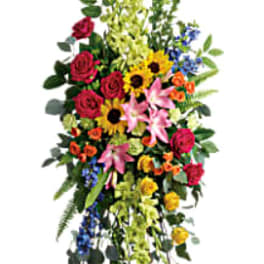Tall standing floral spray with mixed bright flowers on an easel