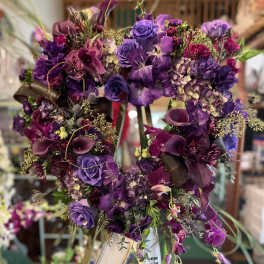 Purple floral heart wreath on an easel with ribbon banners