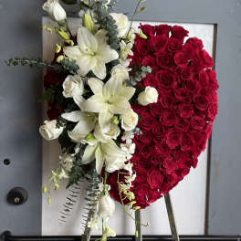 Heart-shaped red rose arrangement with white lilies and roses on an easel