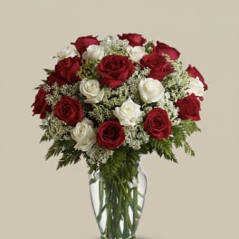 Red and white roses arranged in a clear glass vase
