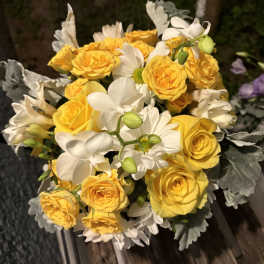 Bouquet of yellow roses and white daisies with silvery foliage