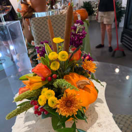 Autumn floral arrangement with orange blooms and a pumpkin accent