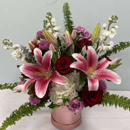 Pink lilies and red roses in a pink vase