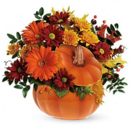 Orange pumpkin arrangement with red and yellow flowers