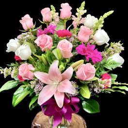 Pink and white rose bouquet with a large pink lily in a glass vase
