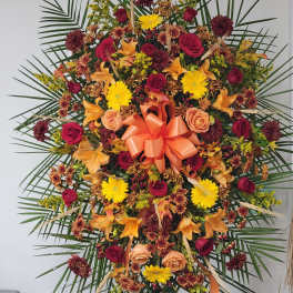 Large standing floral spray with roses, lilies, and yellow daisies