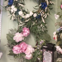 Floral wreath with blue and white flowers on a green wall