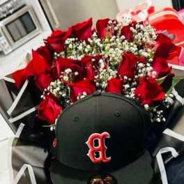 Ramo de rosas rojas y gorra