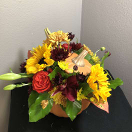 Pumpkin-shaped floral arrangement with sunflowers and roses