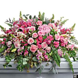 Pink floral casket spray with roses and lilies