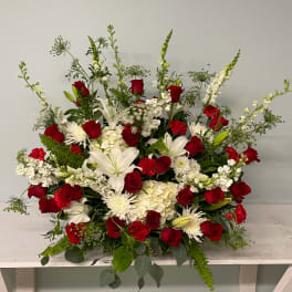 Large red and white floral arrangement with roses and lilies