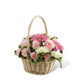 Pink and white flowers arranged in a wicker basket