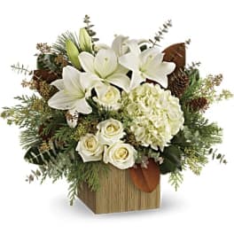 White lilies and roses arranged in a wooden cube vase