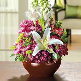 Pink and white floral arrangement in a brown bowl vase
