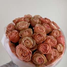 Bouquet of peach roses wrapped in pale pink paper