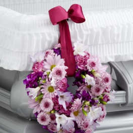 Pink and purple floral wreath with a magenta ribbon bow