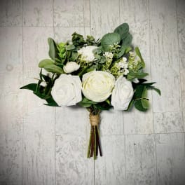 White rose bouquet with mixed greenery on a tiled floor
