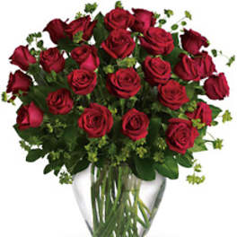 Red roses arranged in a clear glass vase