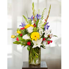 Mixed bouquet of lilies, roses, and daisies in a glass vase