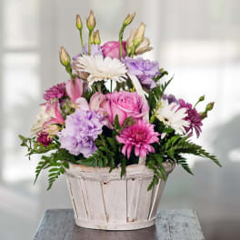 Pink and lavender mixed bouquet in a white wooden basket