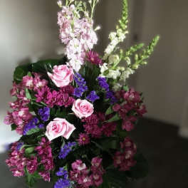 Tall bouquet of pink, purple, and white flowers with dark foliage