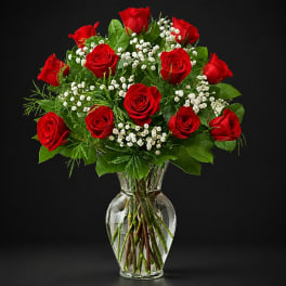 Red roses and white baby's breath in a clear glass vase